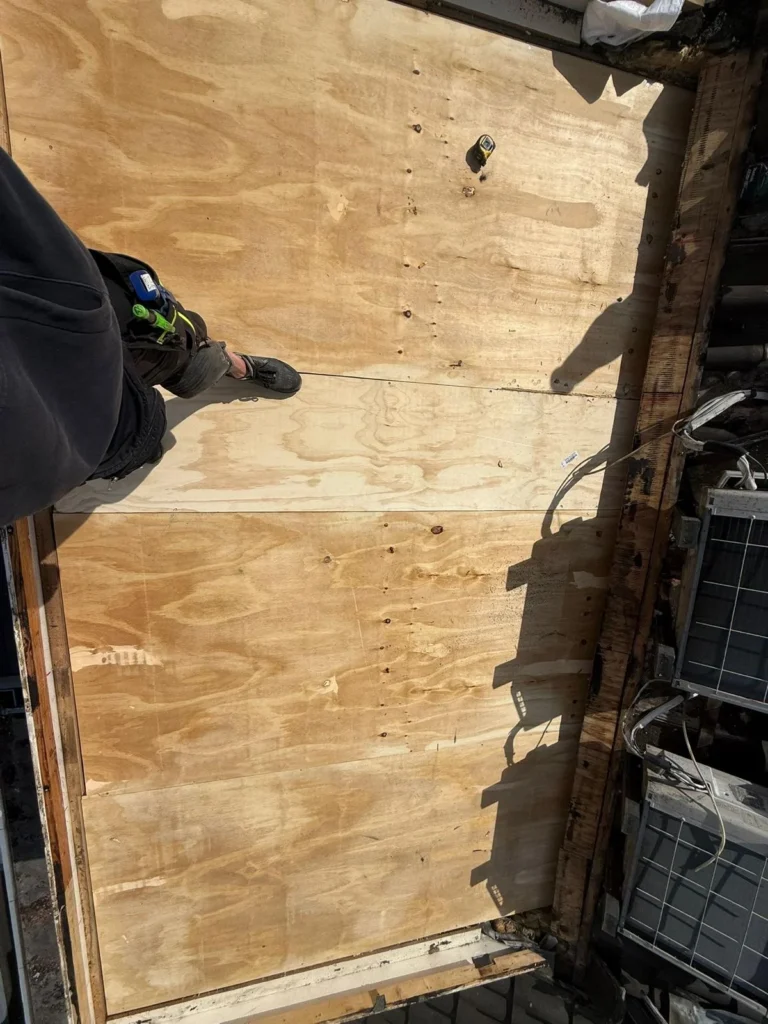 New plywood roof boarding on a flat roof during renovation in Otterlo