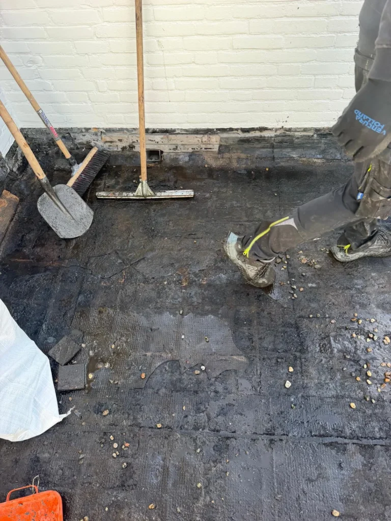 Plat dak van een loods in Ede met natte oude bitumen dakbedekking na het verwijderen van het grind