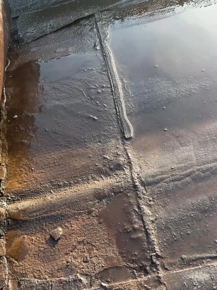 Natte naden in de oude bitumen dakbedekking van een bedrijfshal in Amersfoort