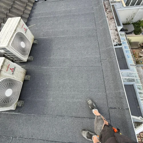 Afgewerkt bitumen plat dak met airco-units op steunen in Ede